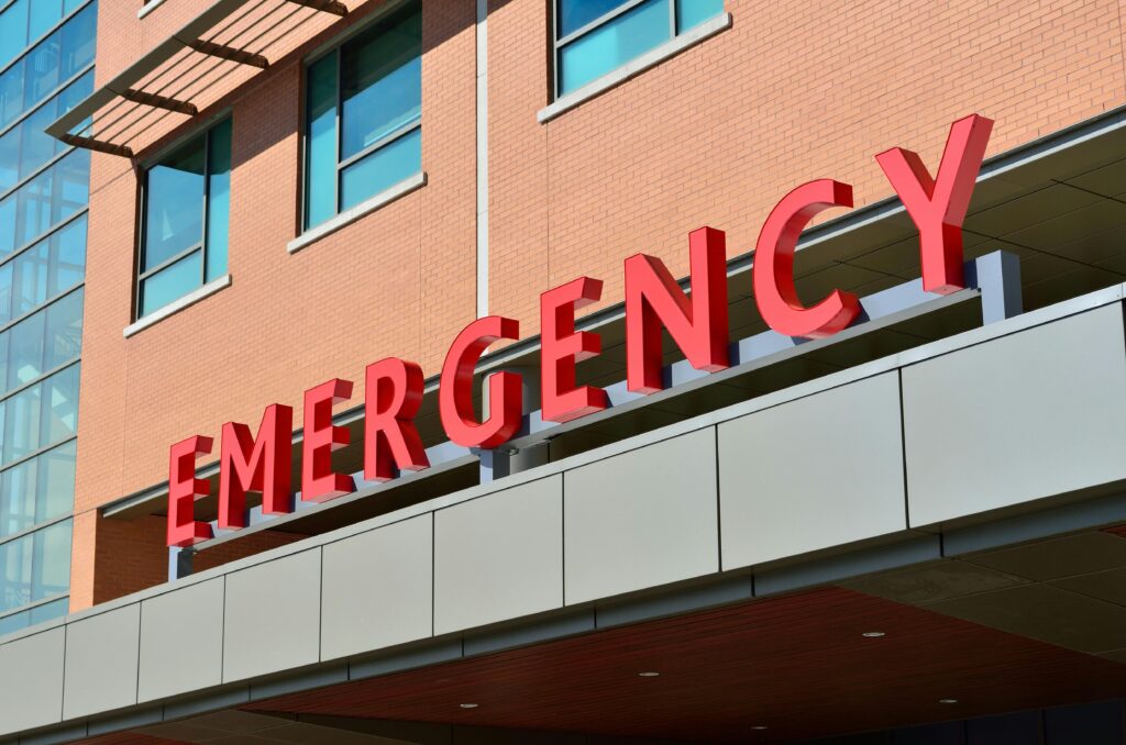 pexels-photo-263402-263402 Close-up of a modern hospital emergency room entrance with prominent red letters.